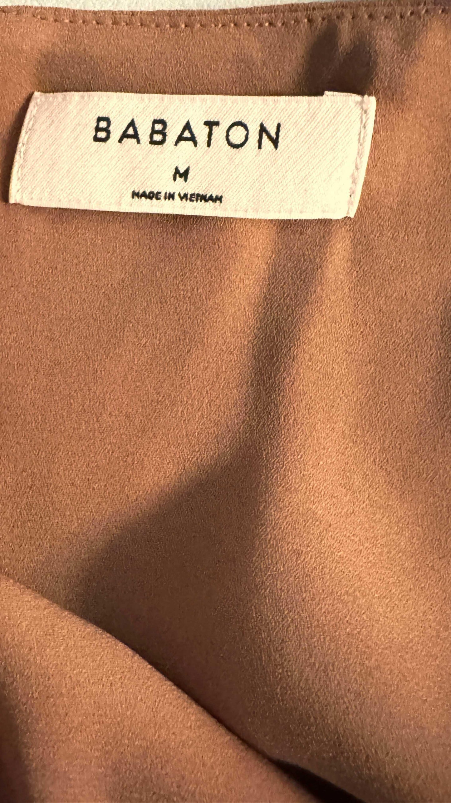 Babaton brown blouse close-up with fabric texture and size medium tag