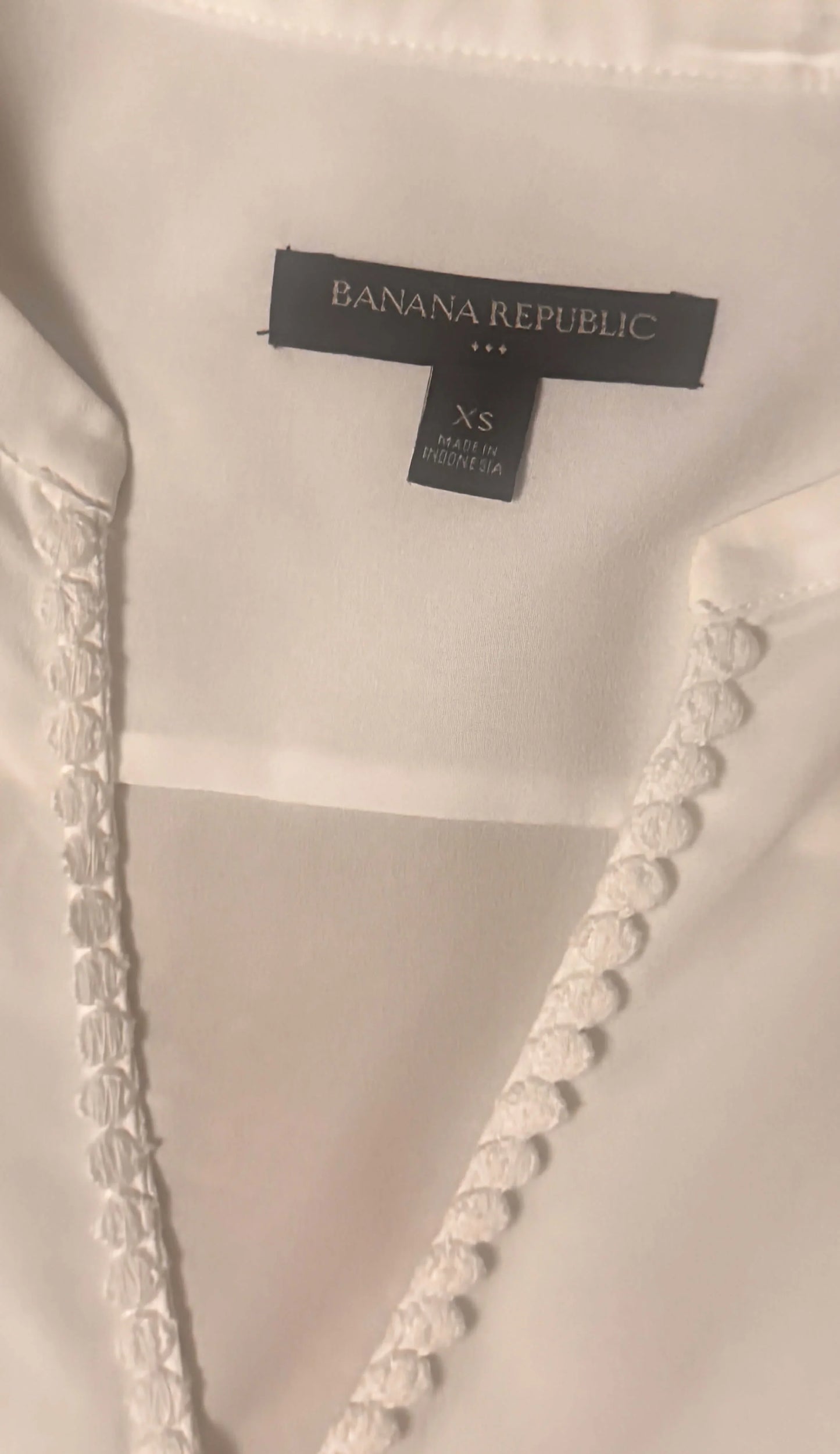 Banana Republic white blouse XS size tag and textured trim detail close-up