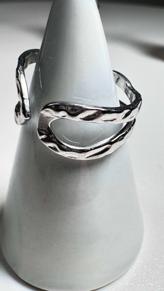 Hammered open sterling silver ring with textured finish on white cone display