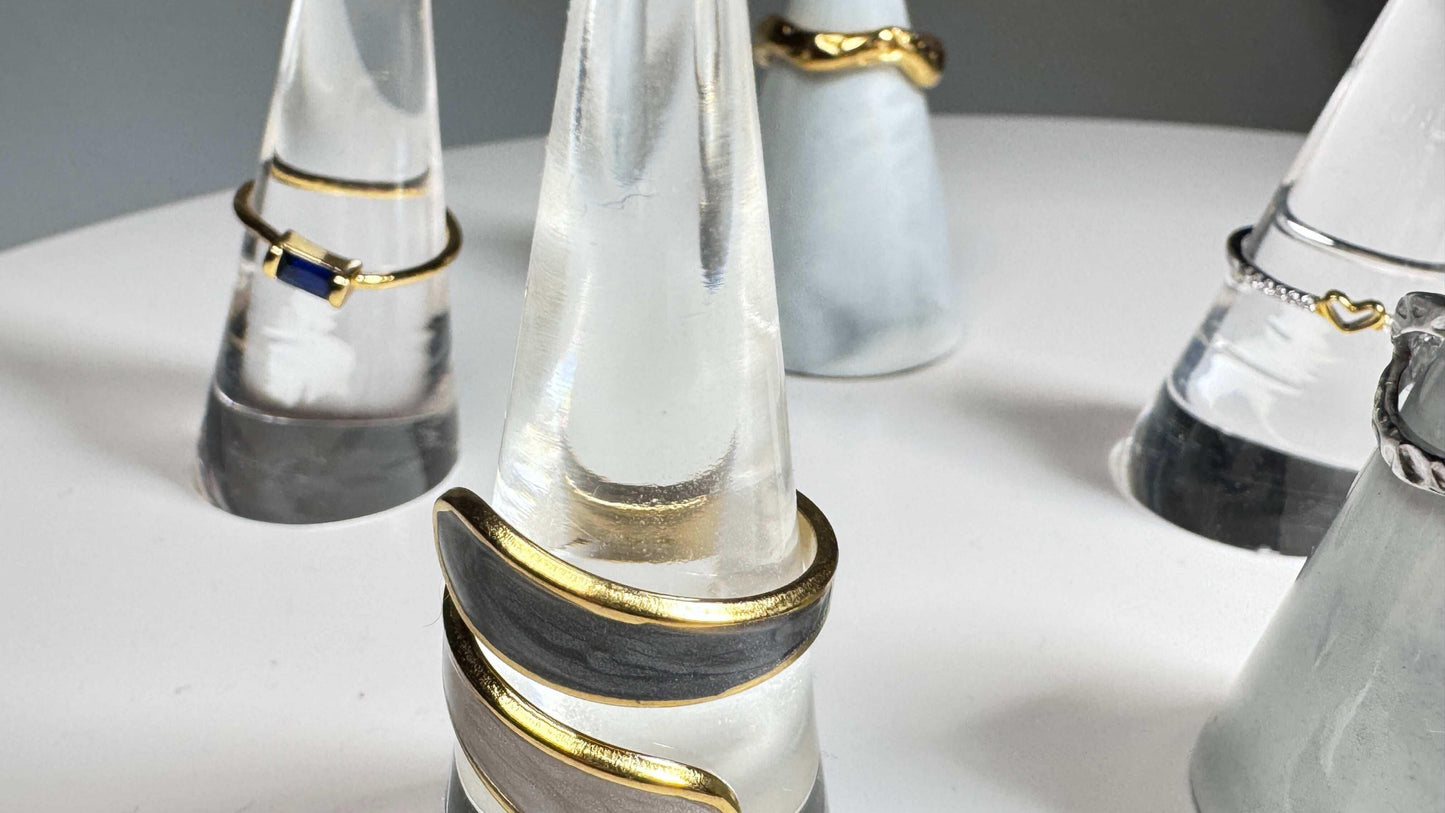 Open natural stone ring with gold accents on marble display, modern minimalist jewelry