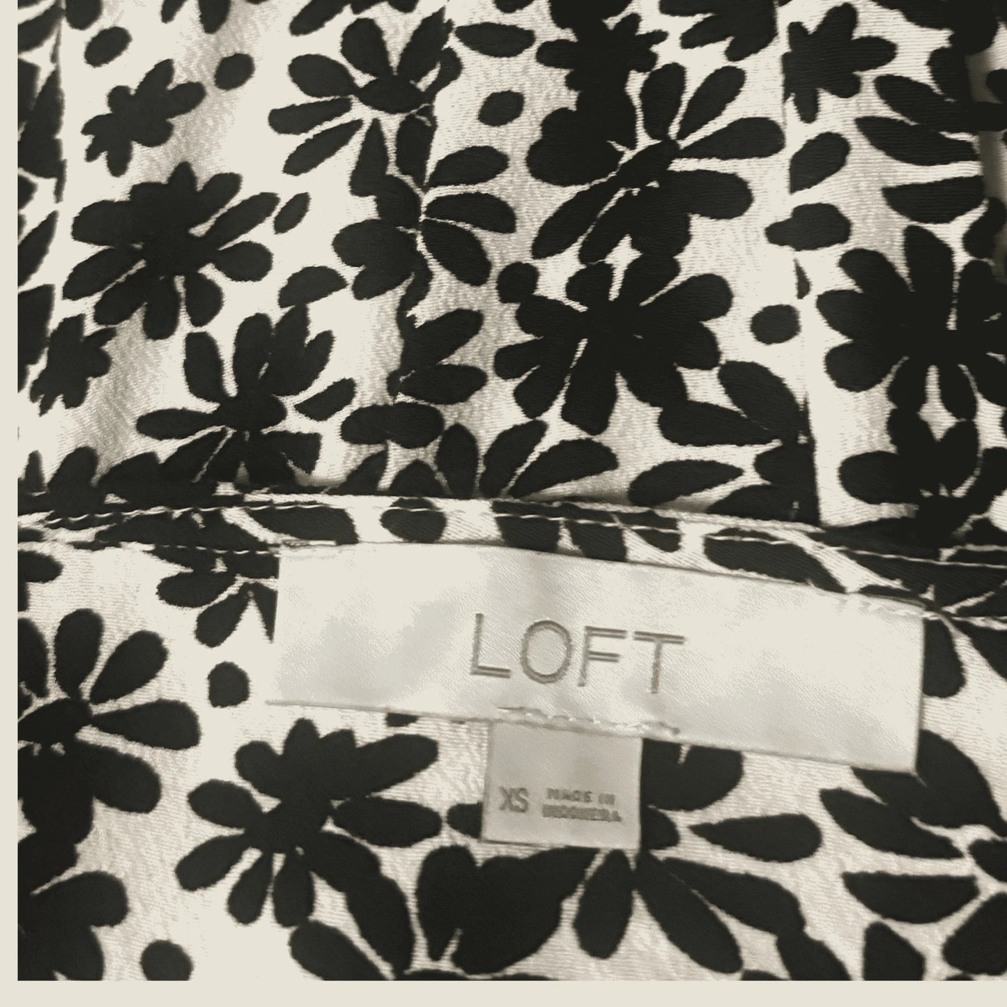 LOFT clothing label on black and white floral patterned fabric, size XS