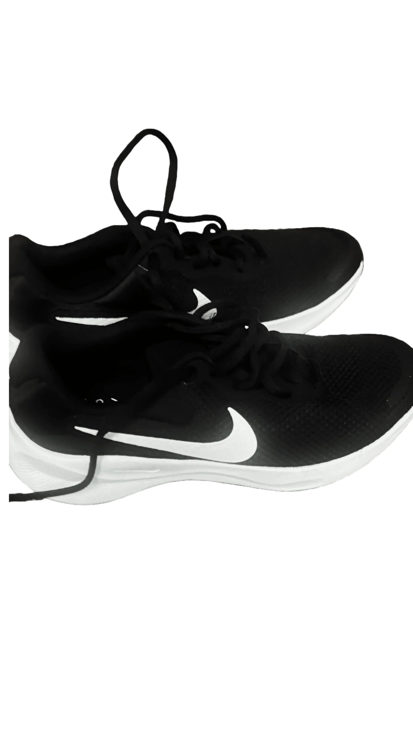 Black Nike athletic shoes with white swoosh and soles on a white background