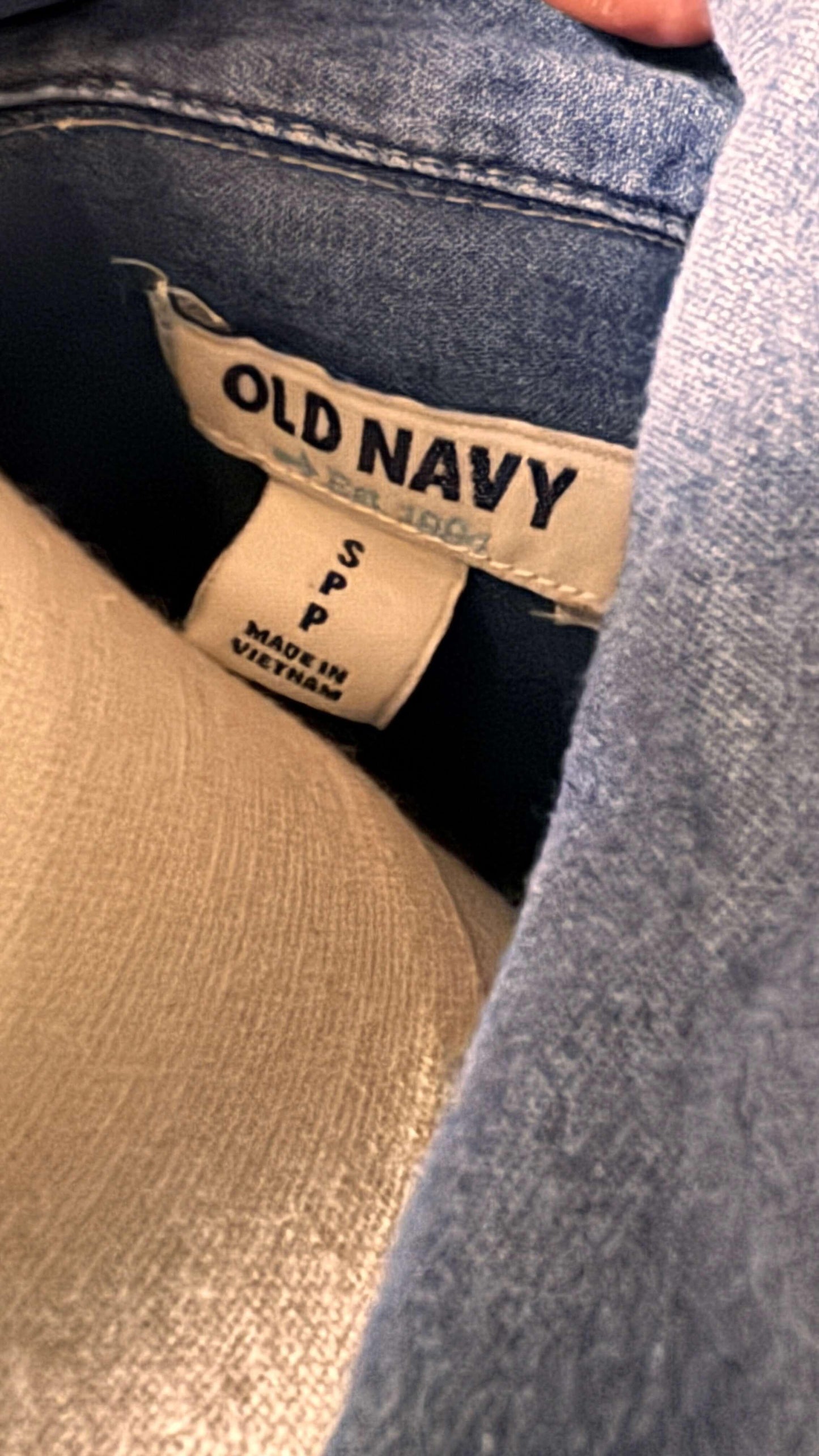 Old Navy dress tag with size S P and Made in Vietnam, inside blue denim garment