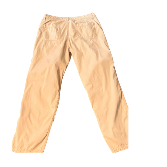 Tan cotton pants with back pockets on a plain background