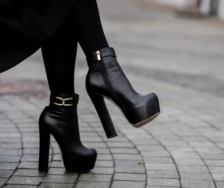 Black platform ankle boots with high heels on city pavement, stylish women's footwear