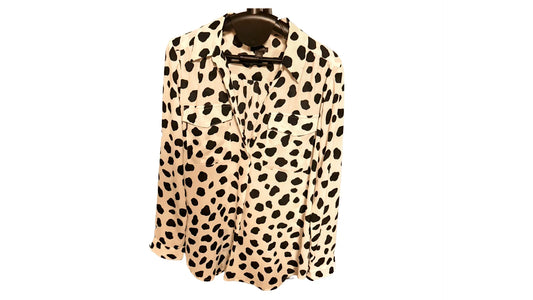 White blouse with black polka dot pattern on hanger, long sleeves and chest pockets