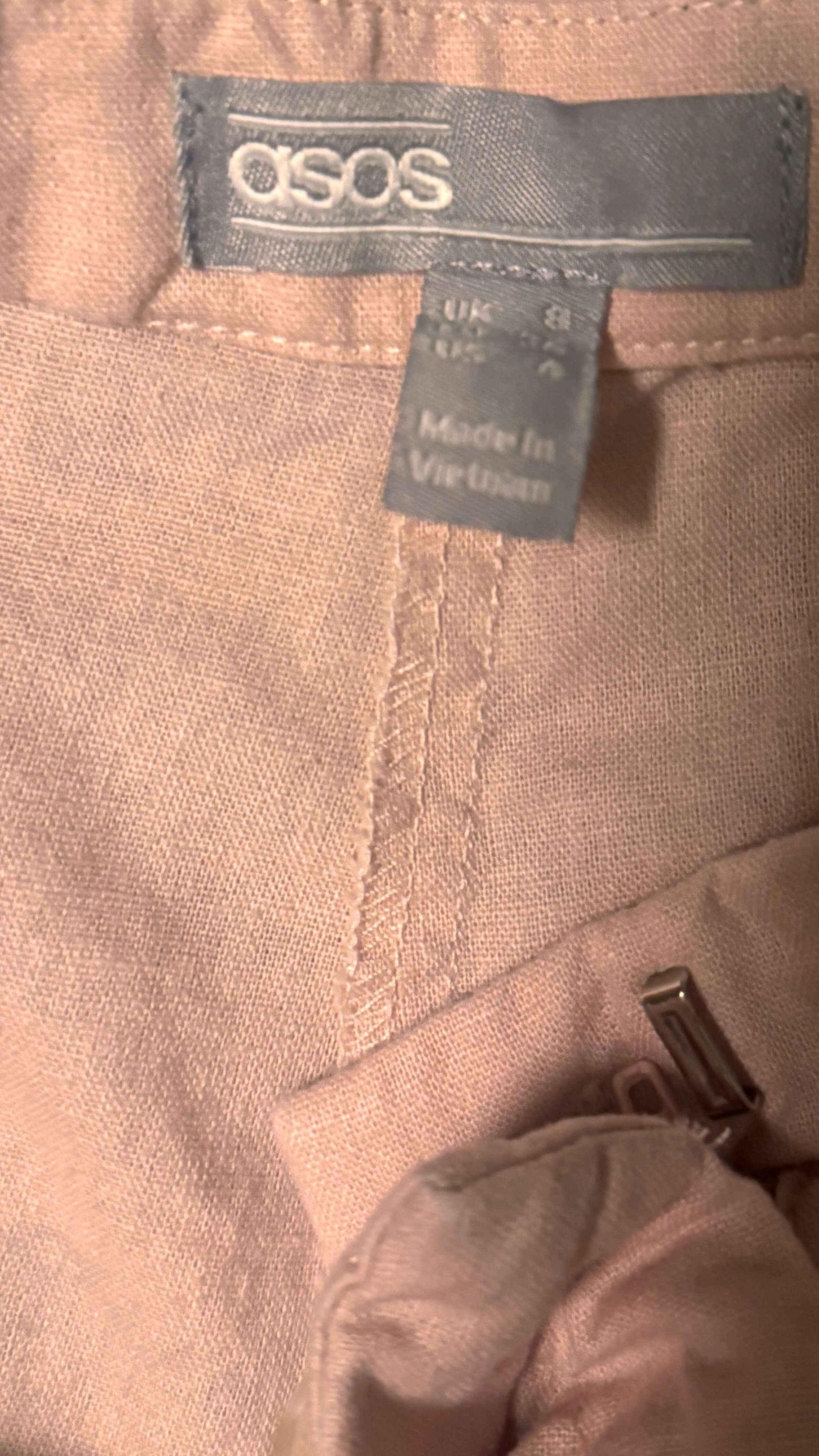 ASOS pink linen shorts with visible label, size tag, and waistband details
