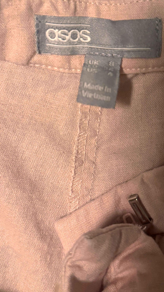 ASOS pink linen shorts with visible label, size tag, and waistband details