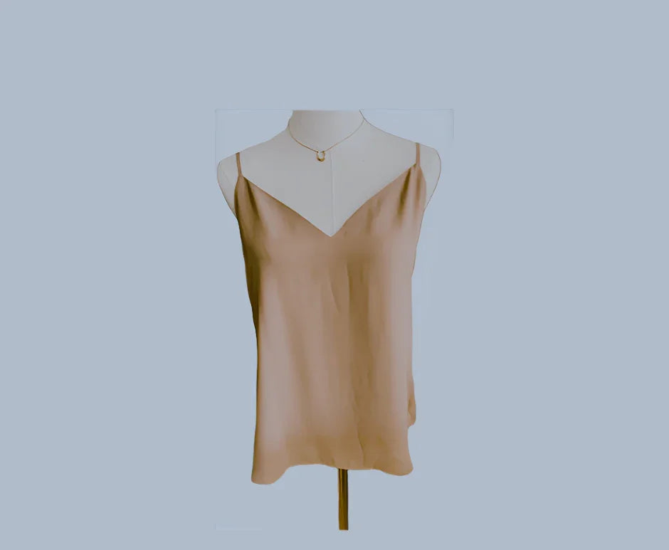 Beige satin Babaton blouse with spaghetti straps on mannequin against light blue background