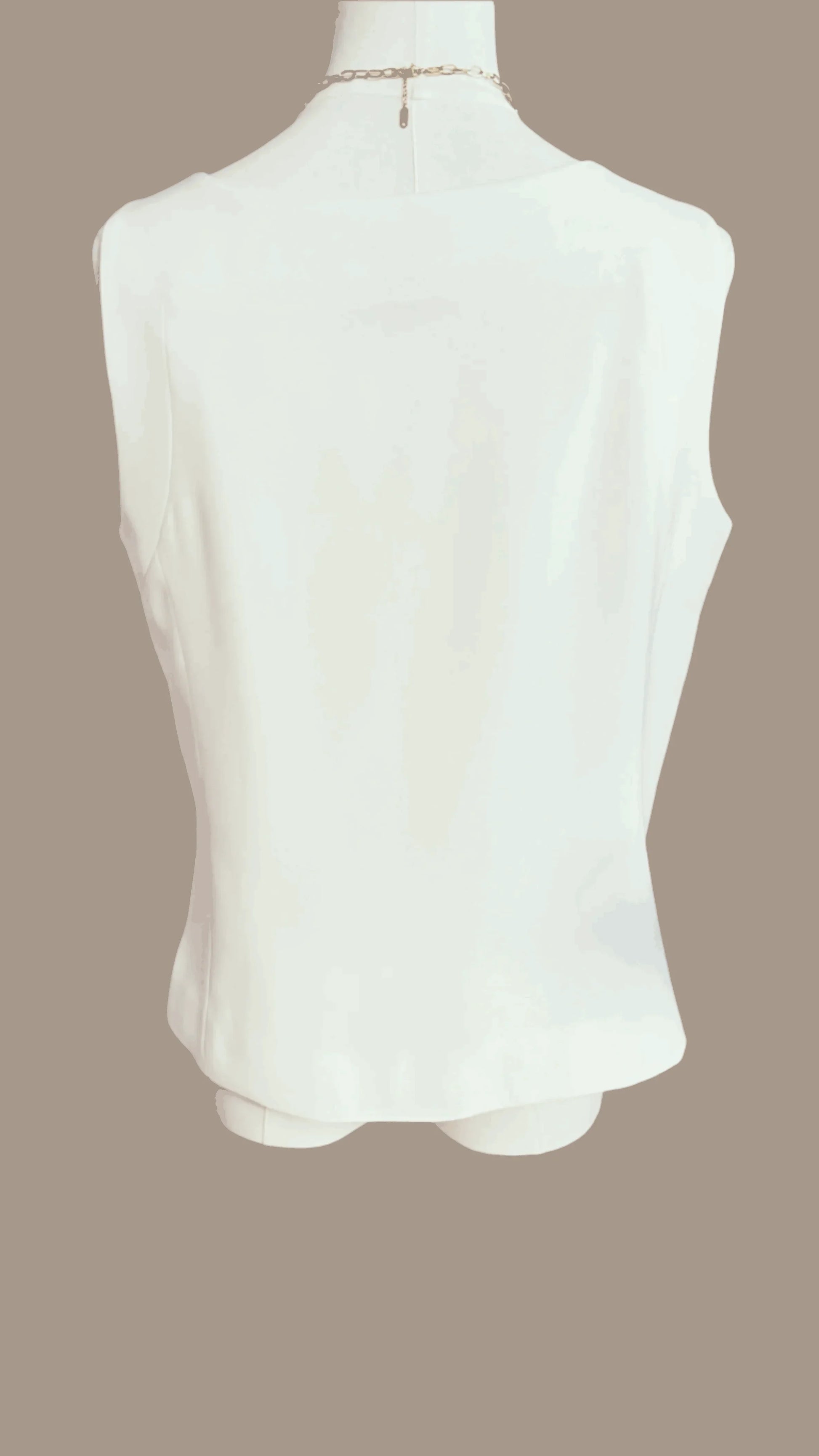 Back view of sleeveless white blouse on mannequin against beige background