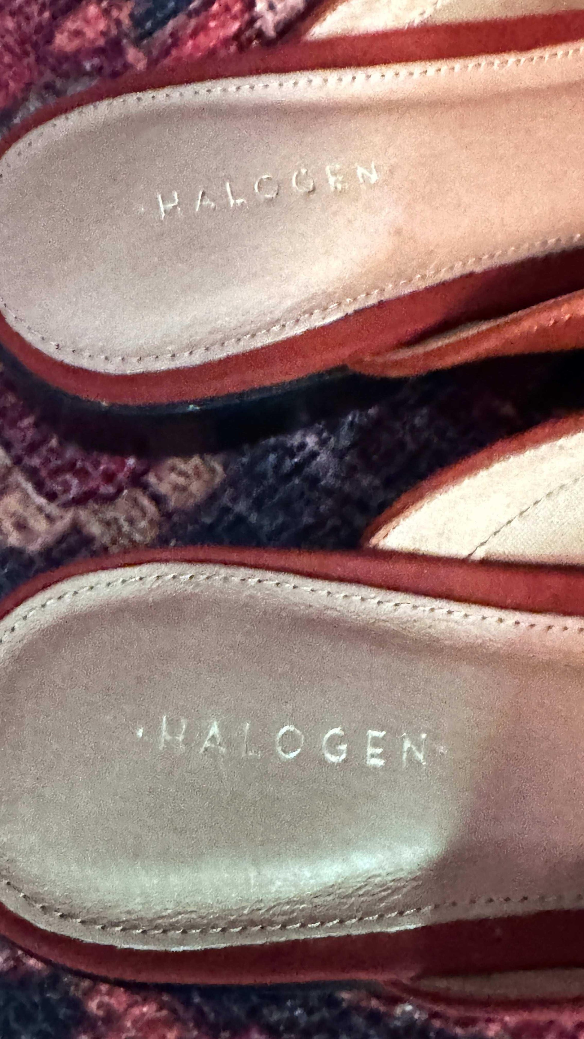 Close-up of burnt orange suede Halogen mules for women on a patterned rug