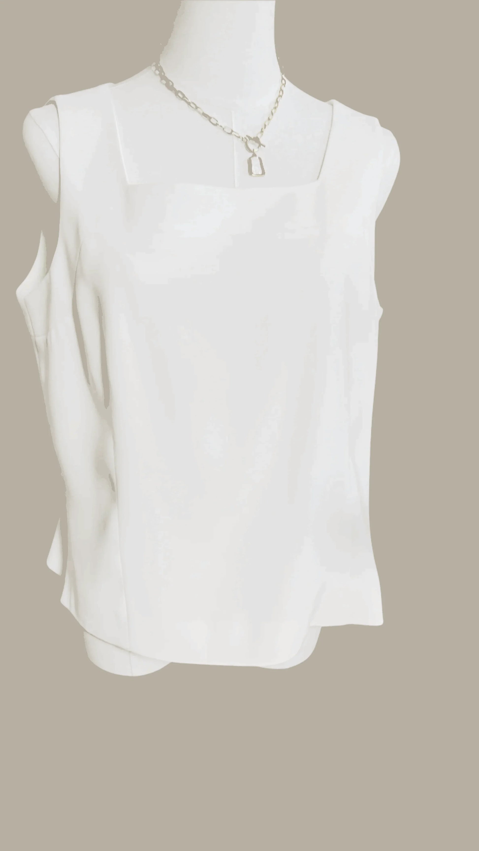 White sleeveless blouse with square neckline on mannequin, minimalist fashion style