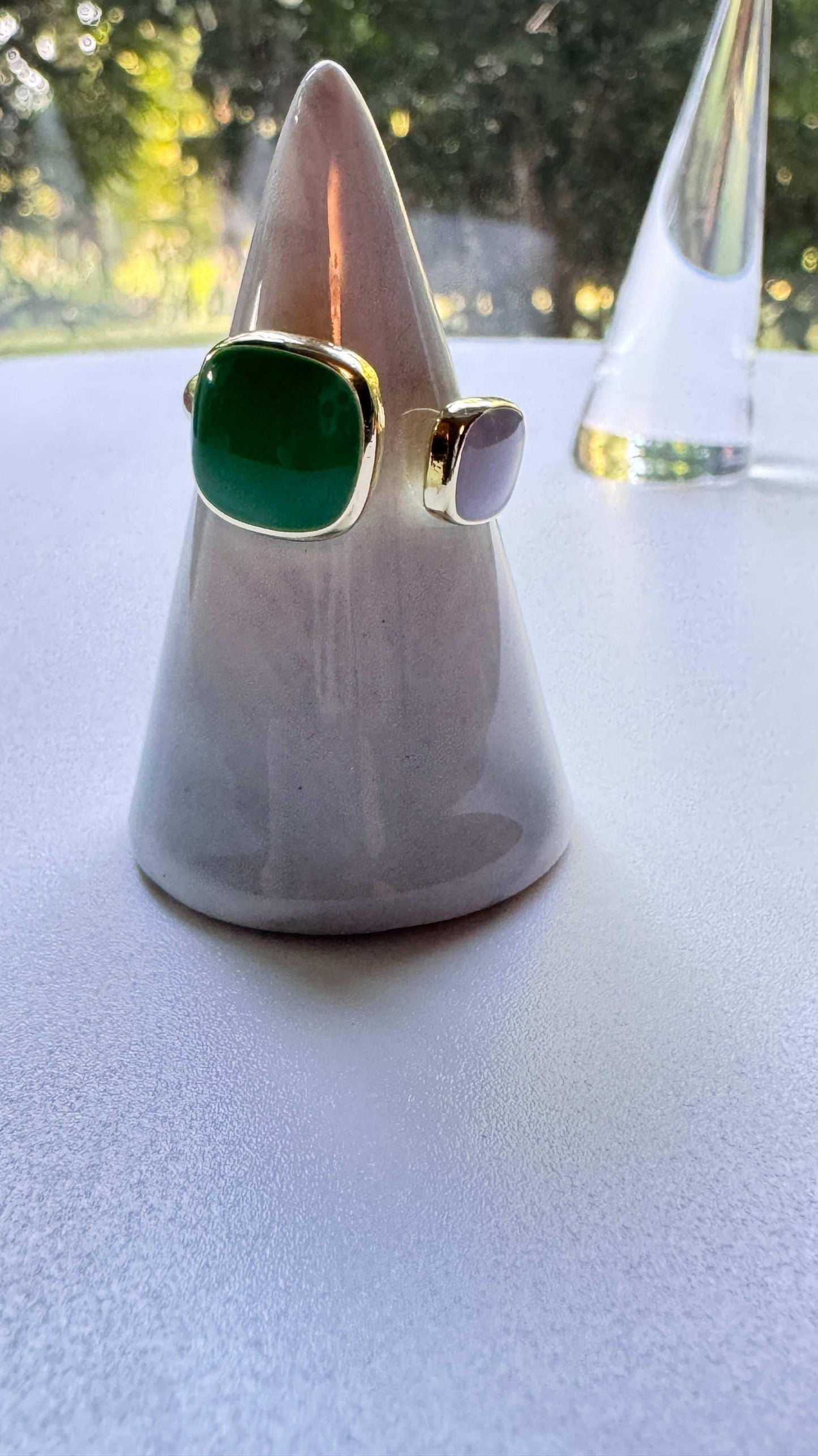 Emerald green open ring with gold band on ceramic cone jewelry holder