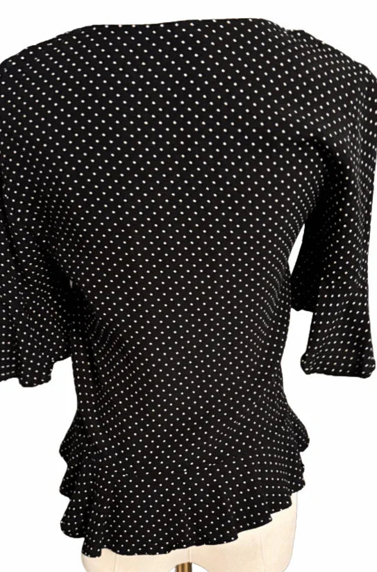 Back view of black H&M blouse with white polka dots on mannequin