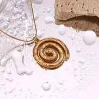 18k gold plated stainless steel spiral pendant necklace on wet surface with stone