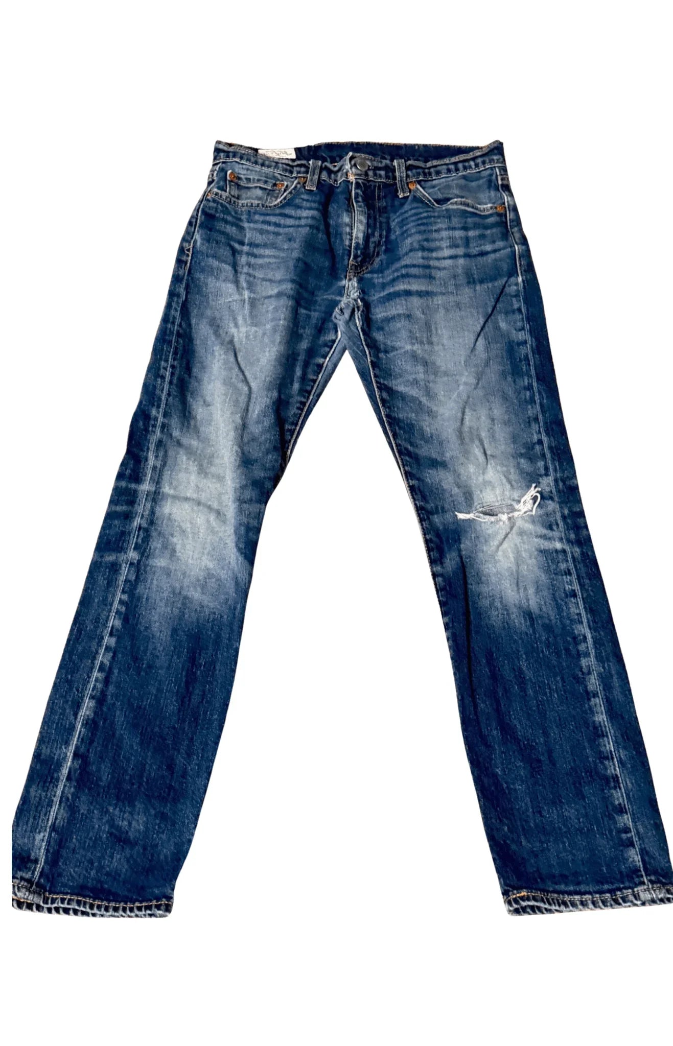 Levi's vintage blue jeans with faded wash and ripped knee, laid flat on white background