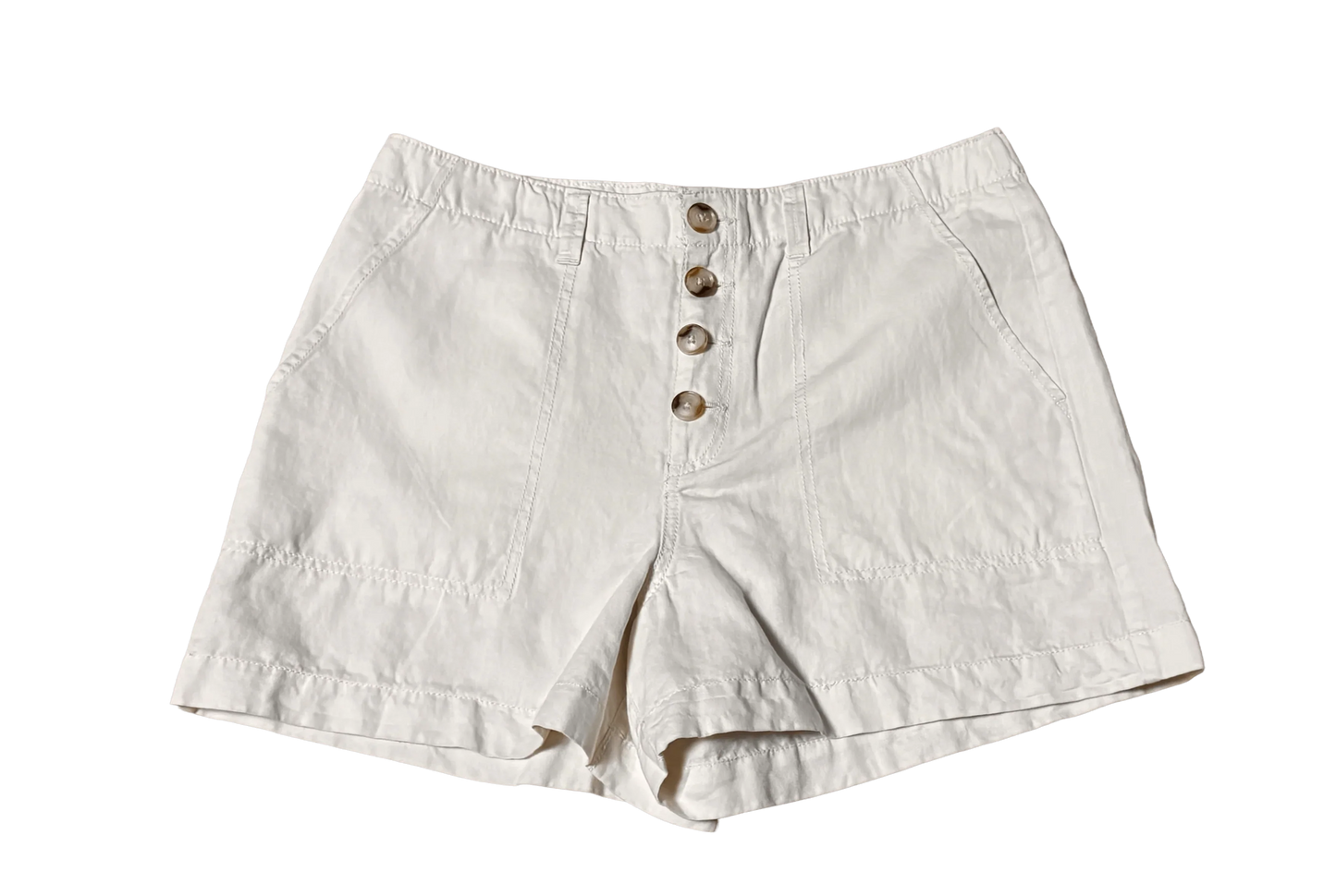 White chino shorts with button front and side pockets on black background