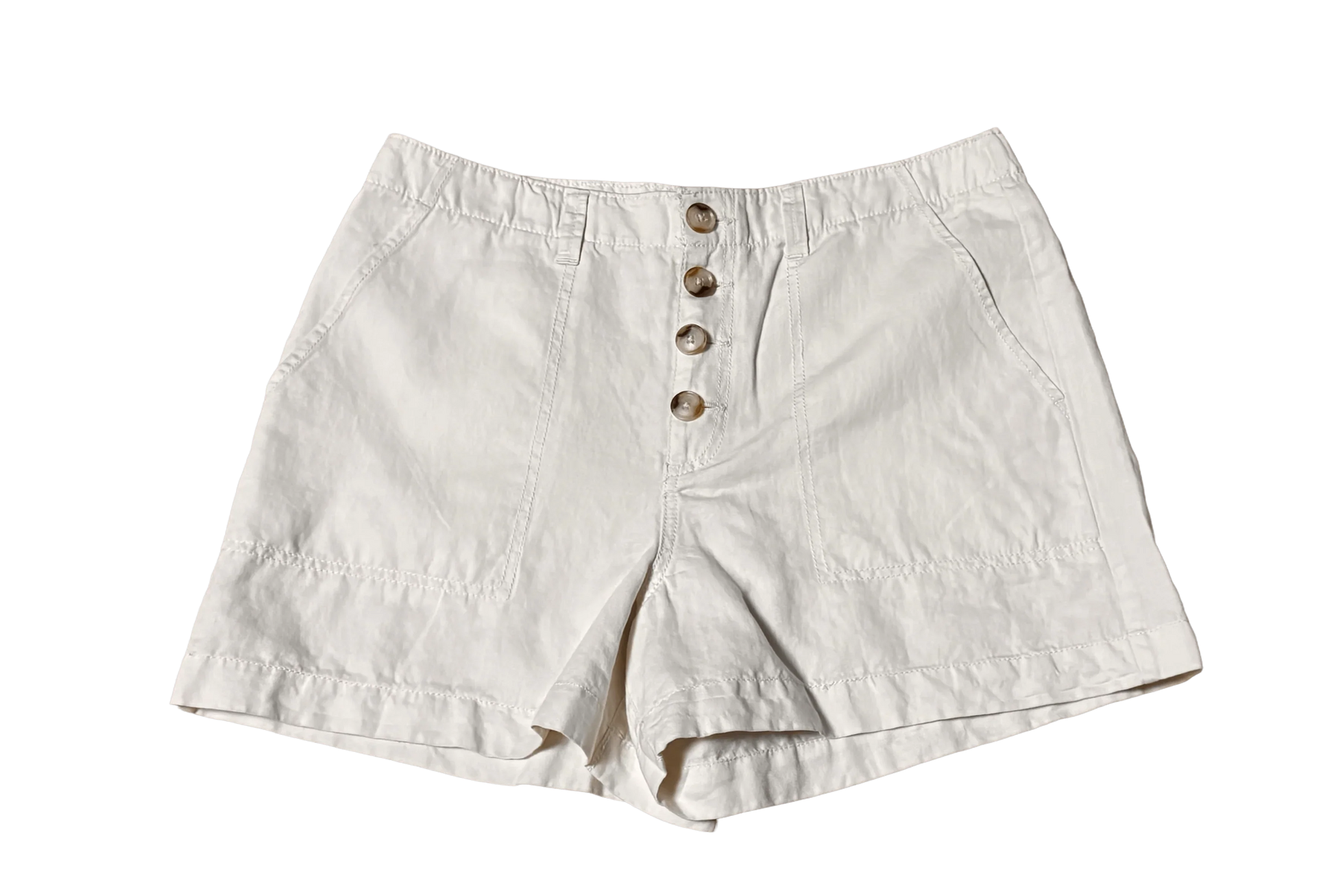 White chino shorts with button front and side pockets on black background