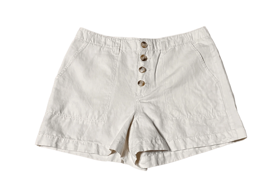 White chino shorts with button front and side pockets on black background