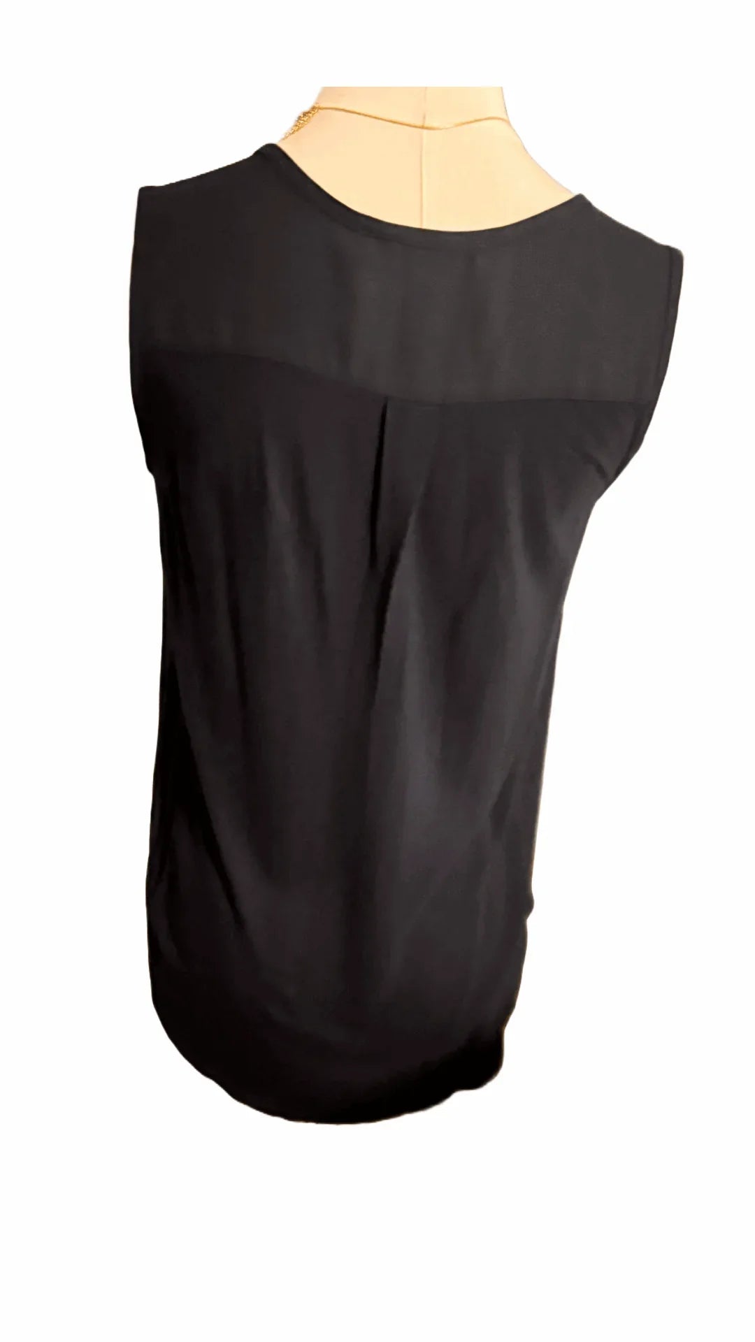 Back view of black sleeveless blouse on mannequin, sheer yoke detail, fashion top