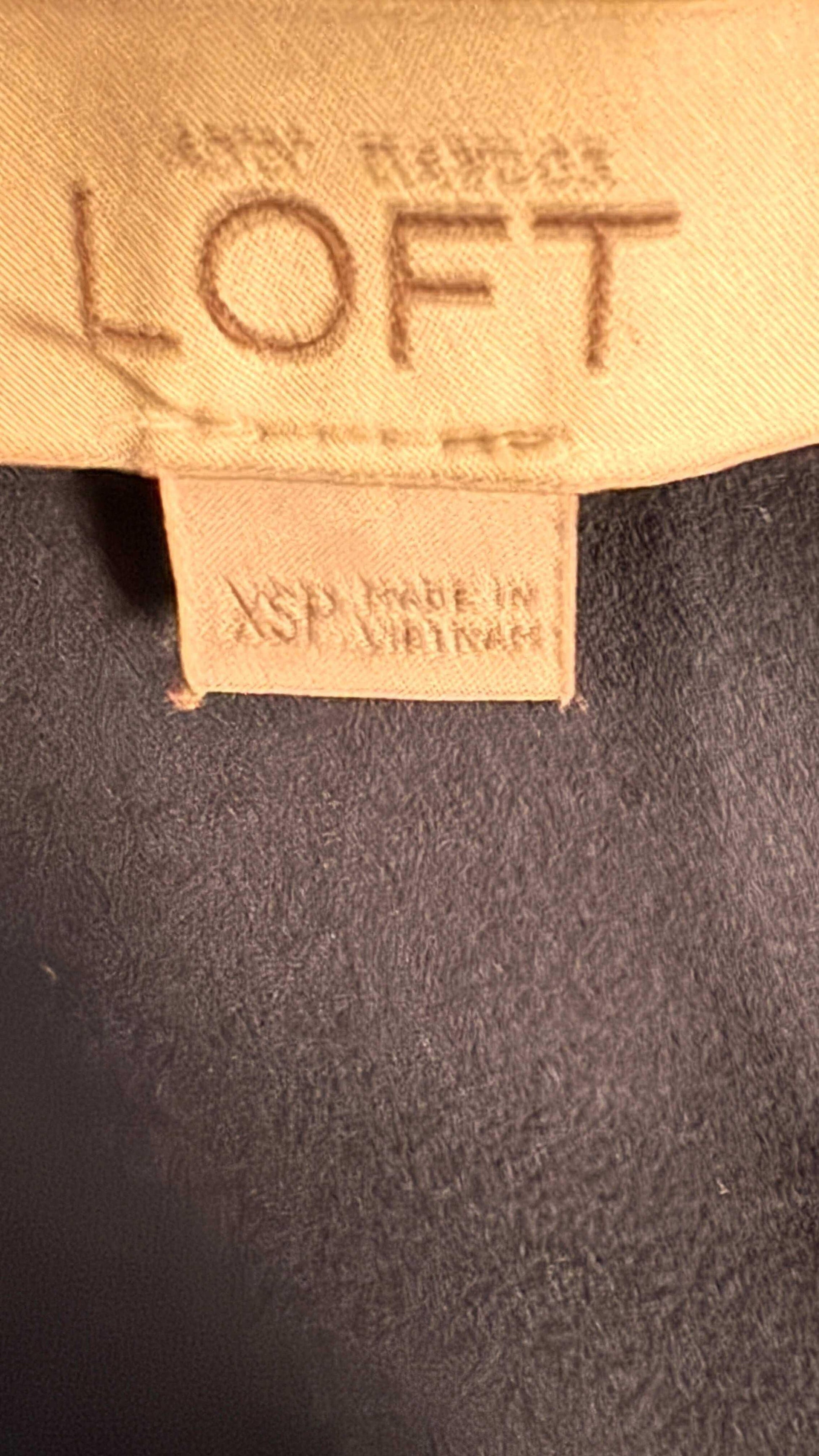 LOFT clothing label XSP size, beige tag on dark fabric, made in Vietnam