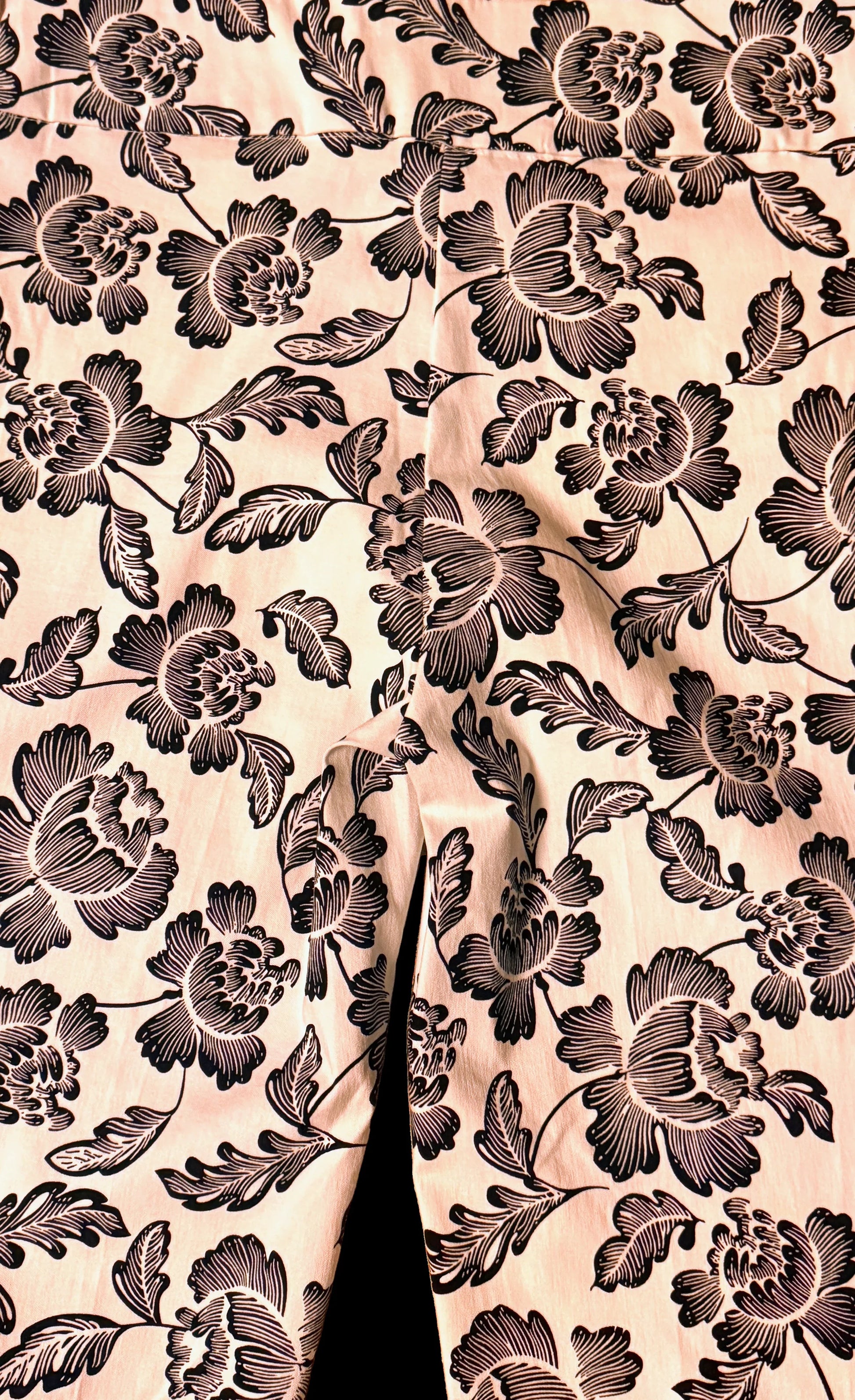 Close up of petite printed pants with black floral pattern on light fabric