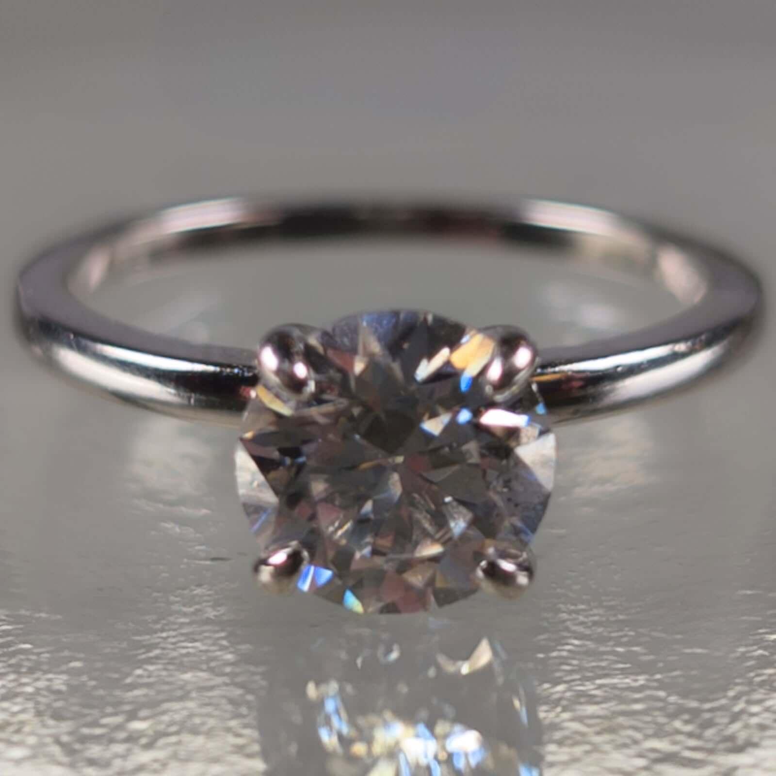 Solitaire moissanite engagement ring with round brilliant stone on silver band