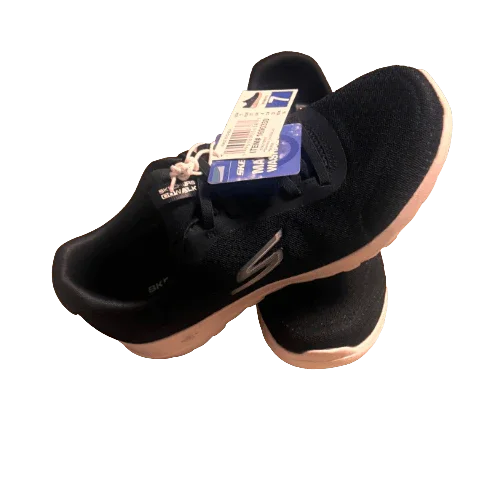Black Skechers walking sneakers with white soles and tags, isolated on white background.