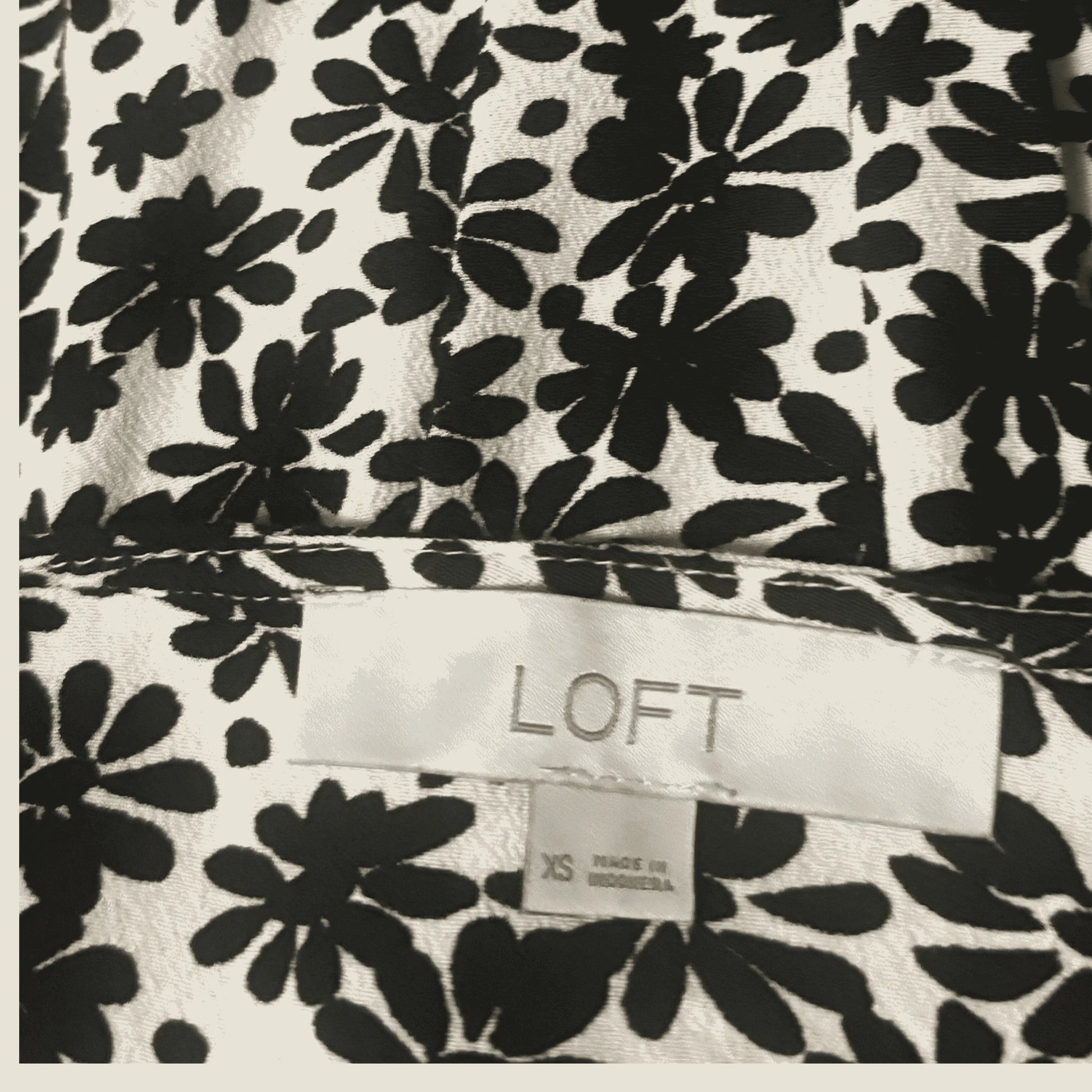 LOFT clothing label on black and white floral patterned fabric, size XS