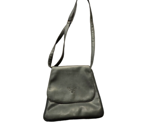 Black Prada leather shoulder bag with adjustable strap on a plain background