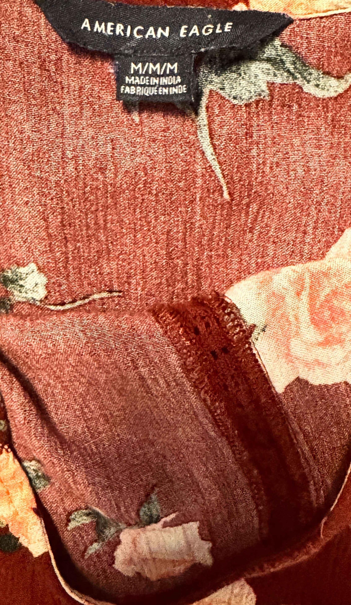 American Eagle red floral sleeveless blouse with lace detail and garment tag view