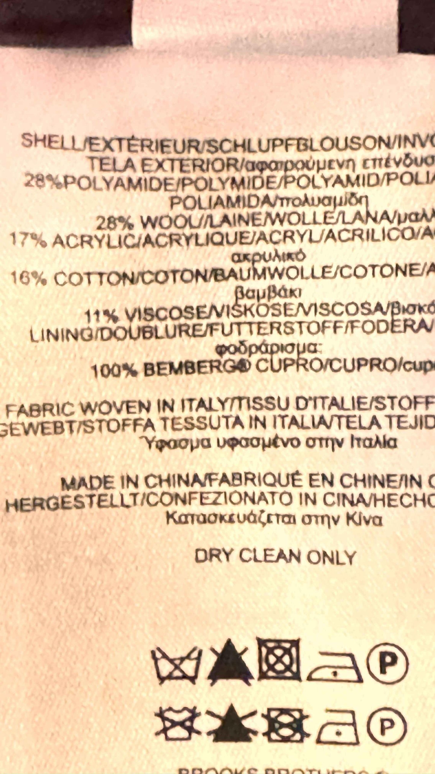 Brooks Brothers clothing tag showing fabric content, care instructions, and multi-language text.