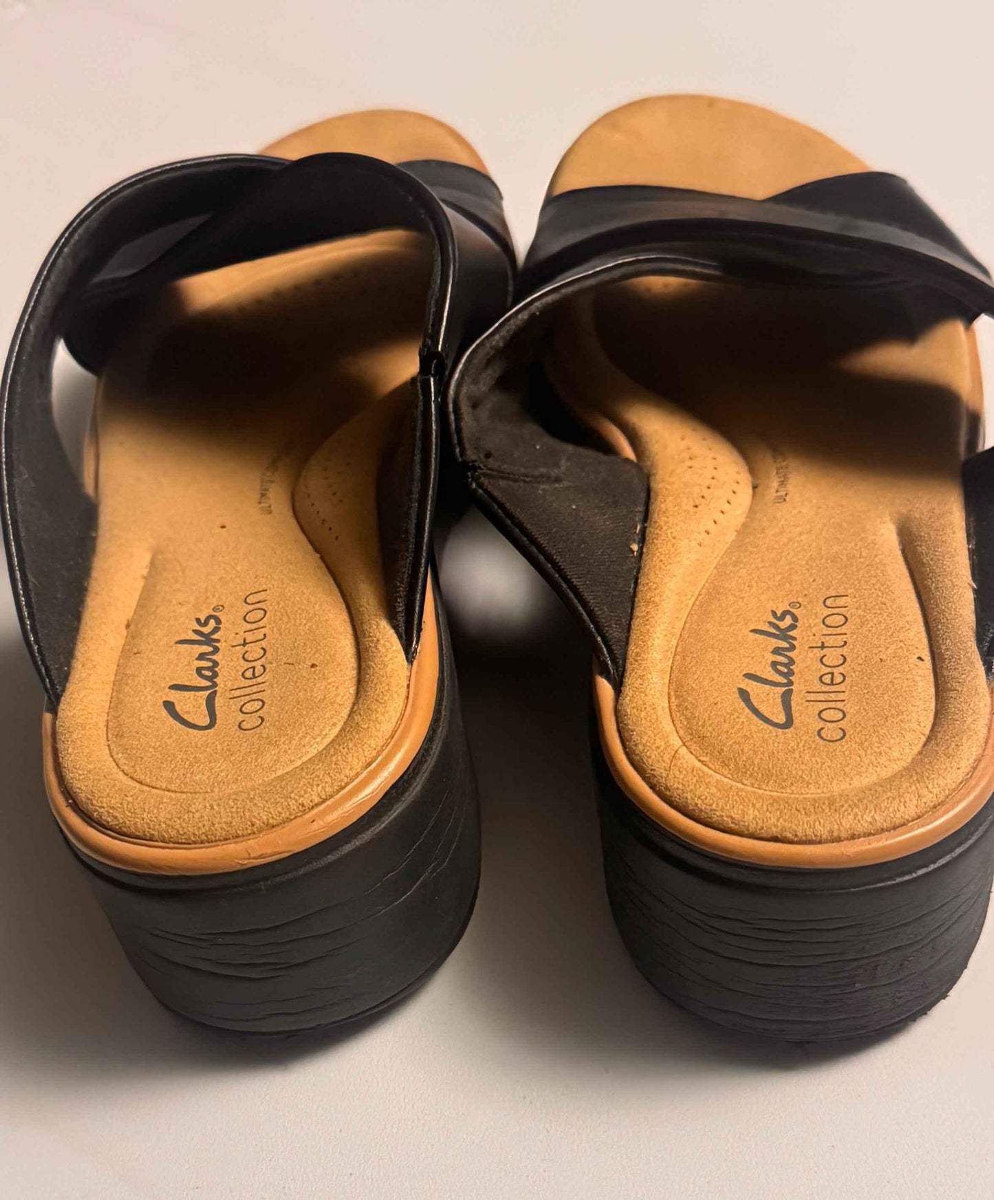 Back view of black Clarks Collection women's sandals with cushioned tan insoles
