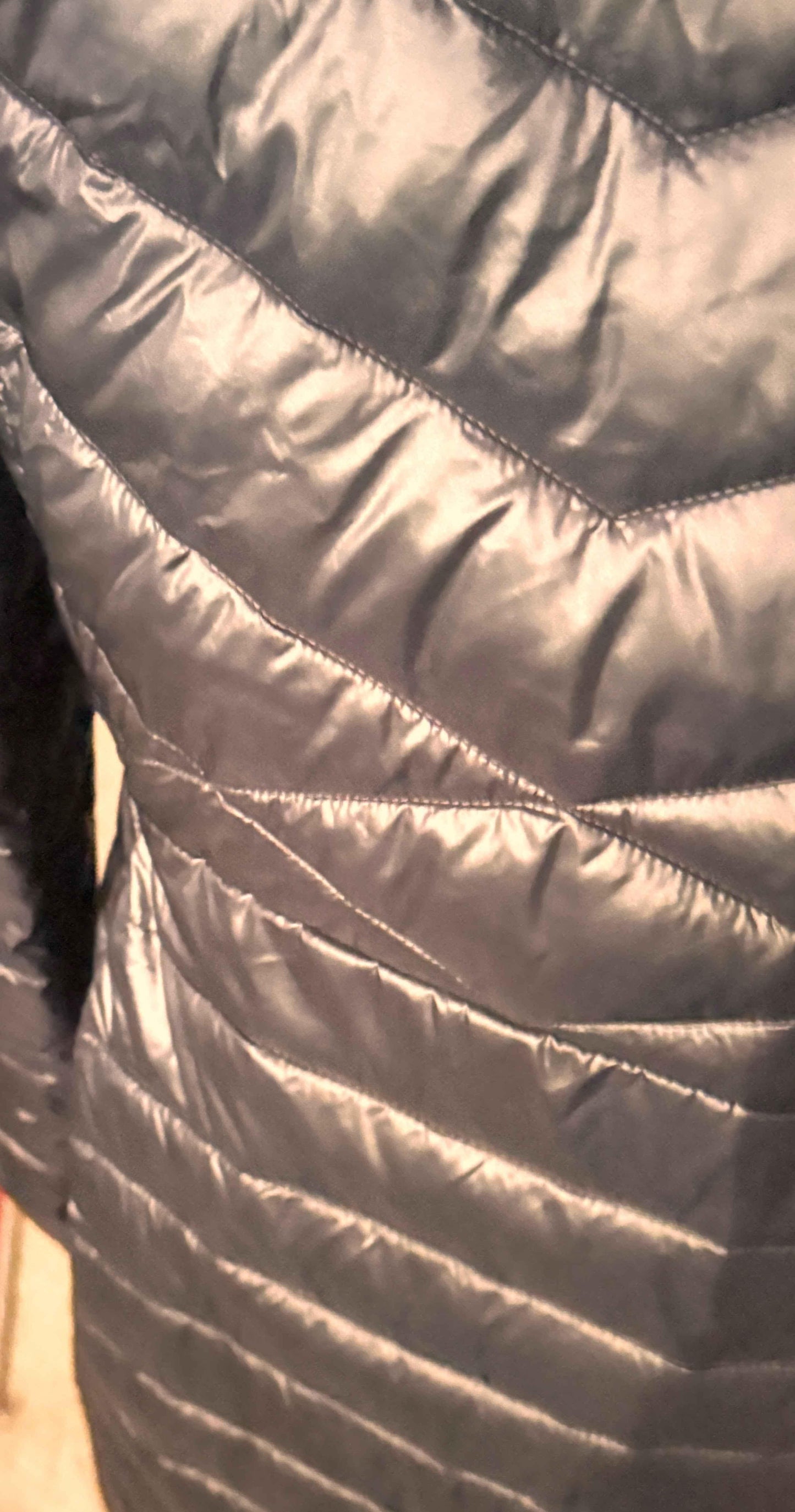 Closeup of black Columbia women's puffer coat with chevron quilted pattern