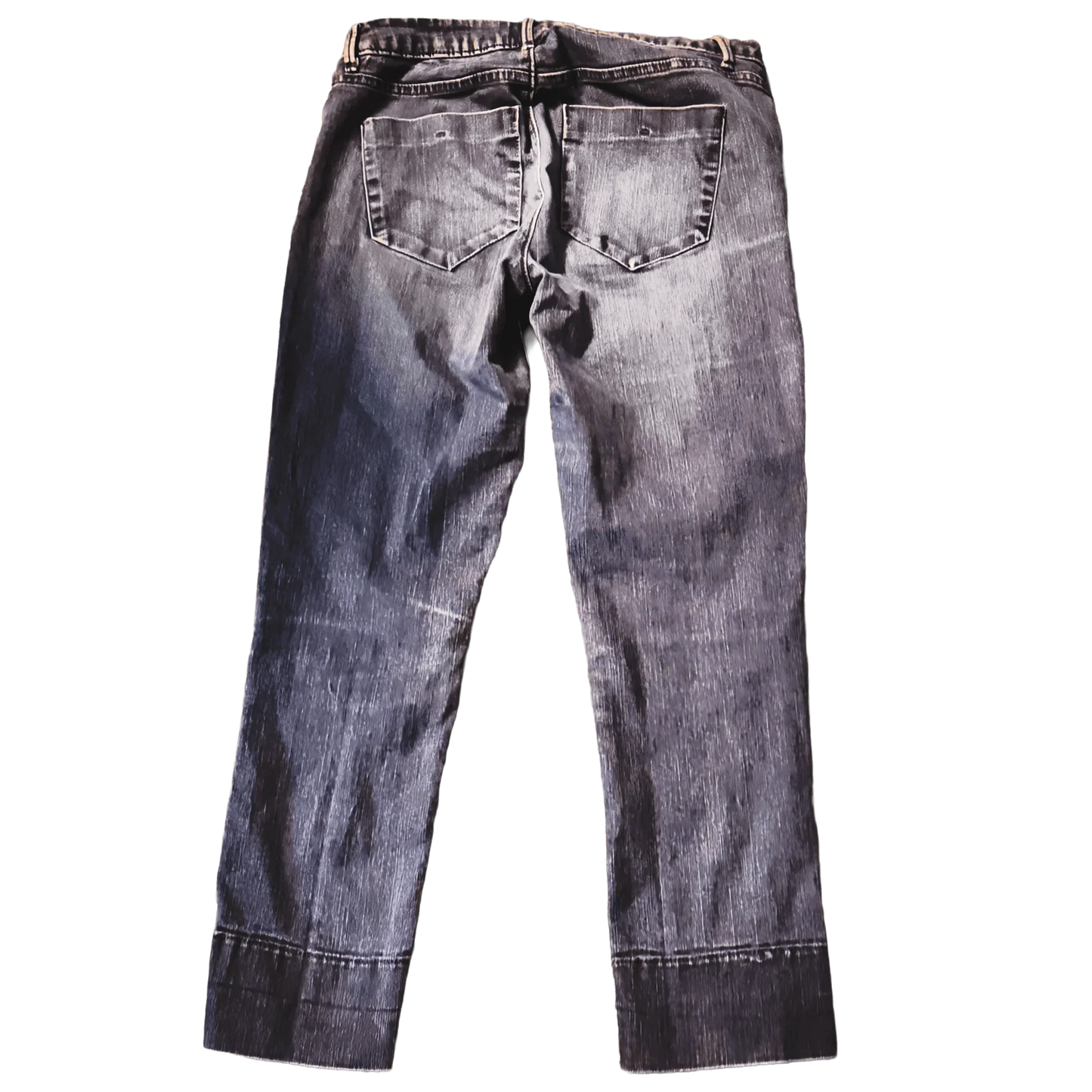 Back view of faded black denim jeans with two rear pockets on green background