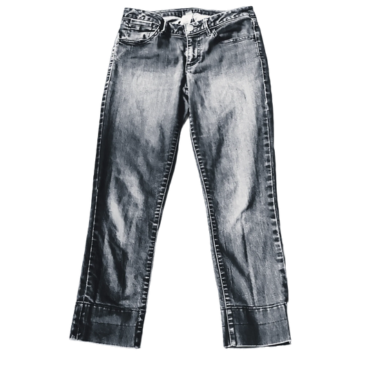 Front view of washed denim jeans with cuffed hems on a white background