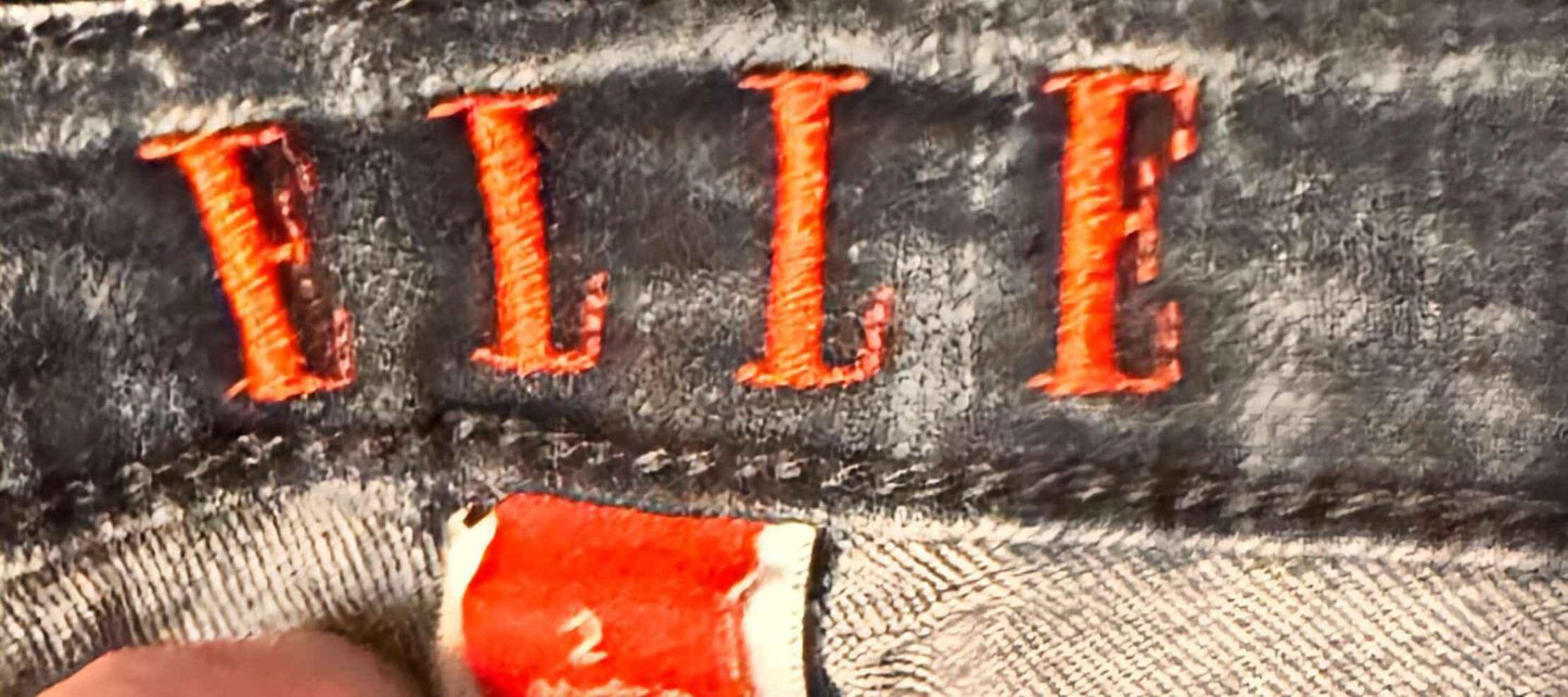 ELLE embroidered orange logo on blue denim jeans tag close-up