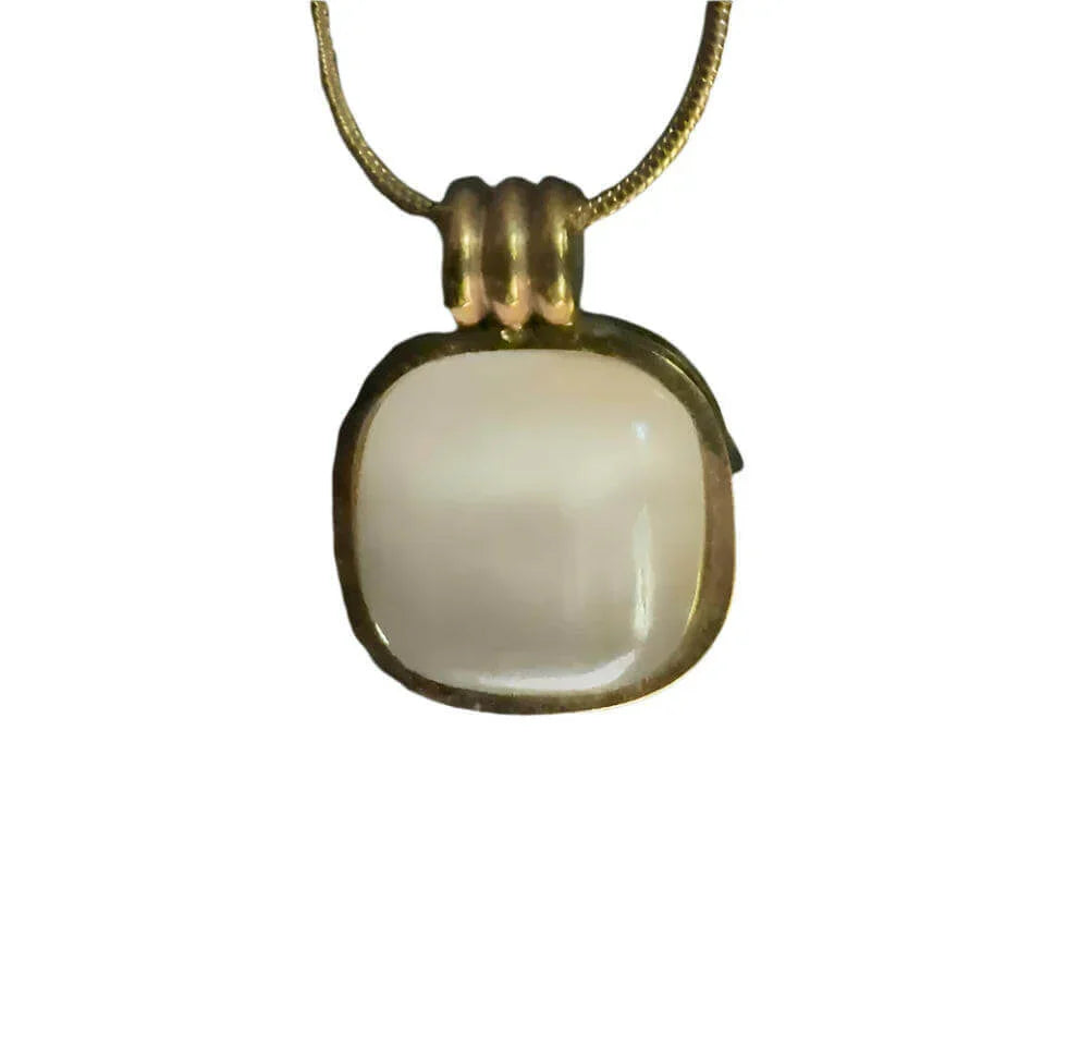 Gold chain necklace with square white gemstone pendant on white background