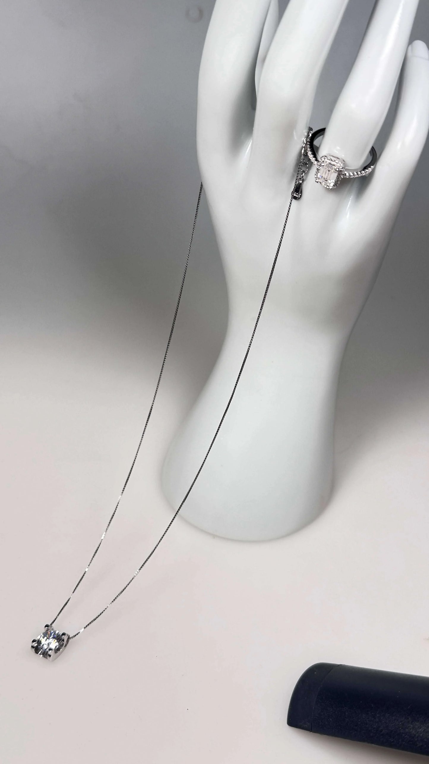 Moissanite lab grown diamond necklace and ring on white mannequin hand