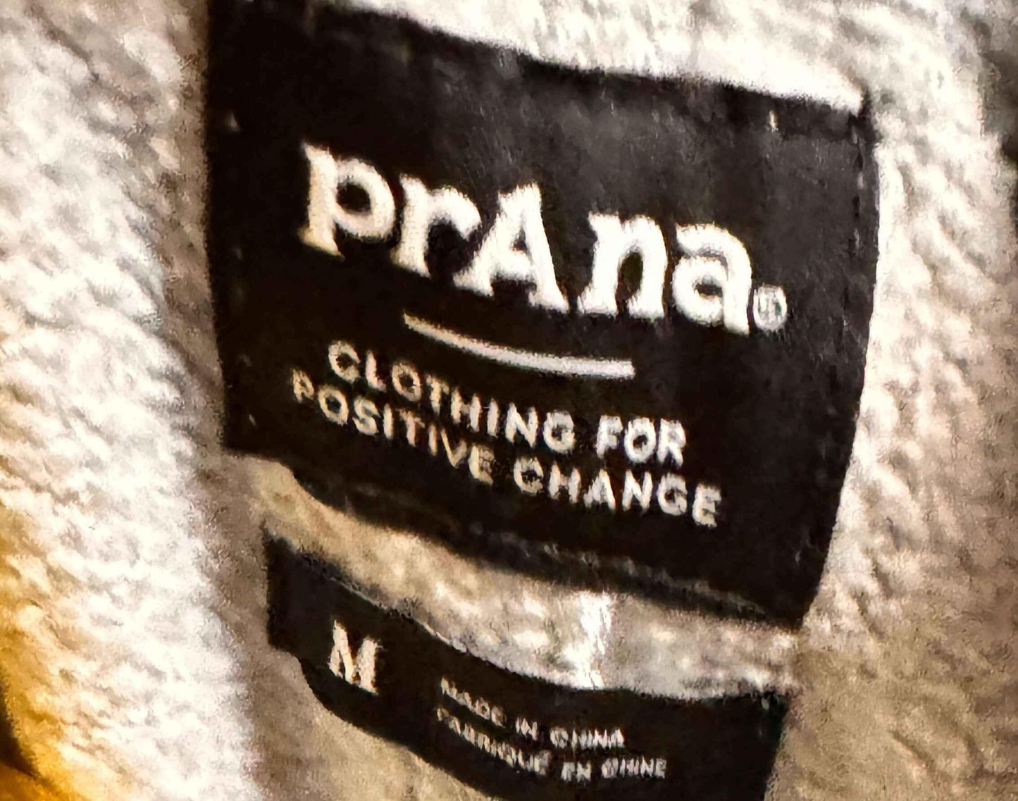prAna clothing label on fleece fabric, sustainable apparel brand tag, medium size