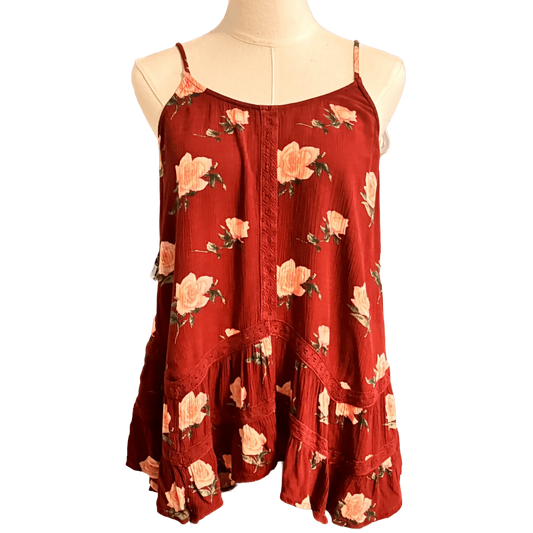 Red floral sleeveless blouse with ruffle hem and thin straps on a mannequin