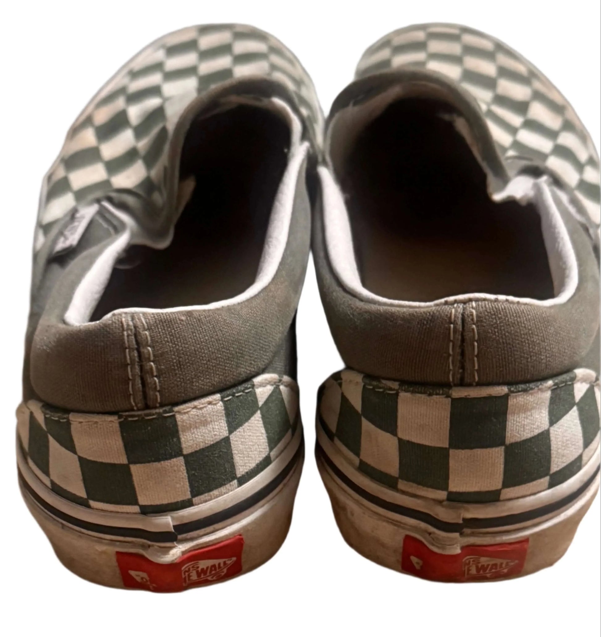 Back view of worn Vans slip-on shoes with green checkered pattern and Off the Wall logo