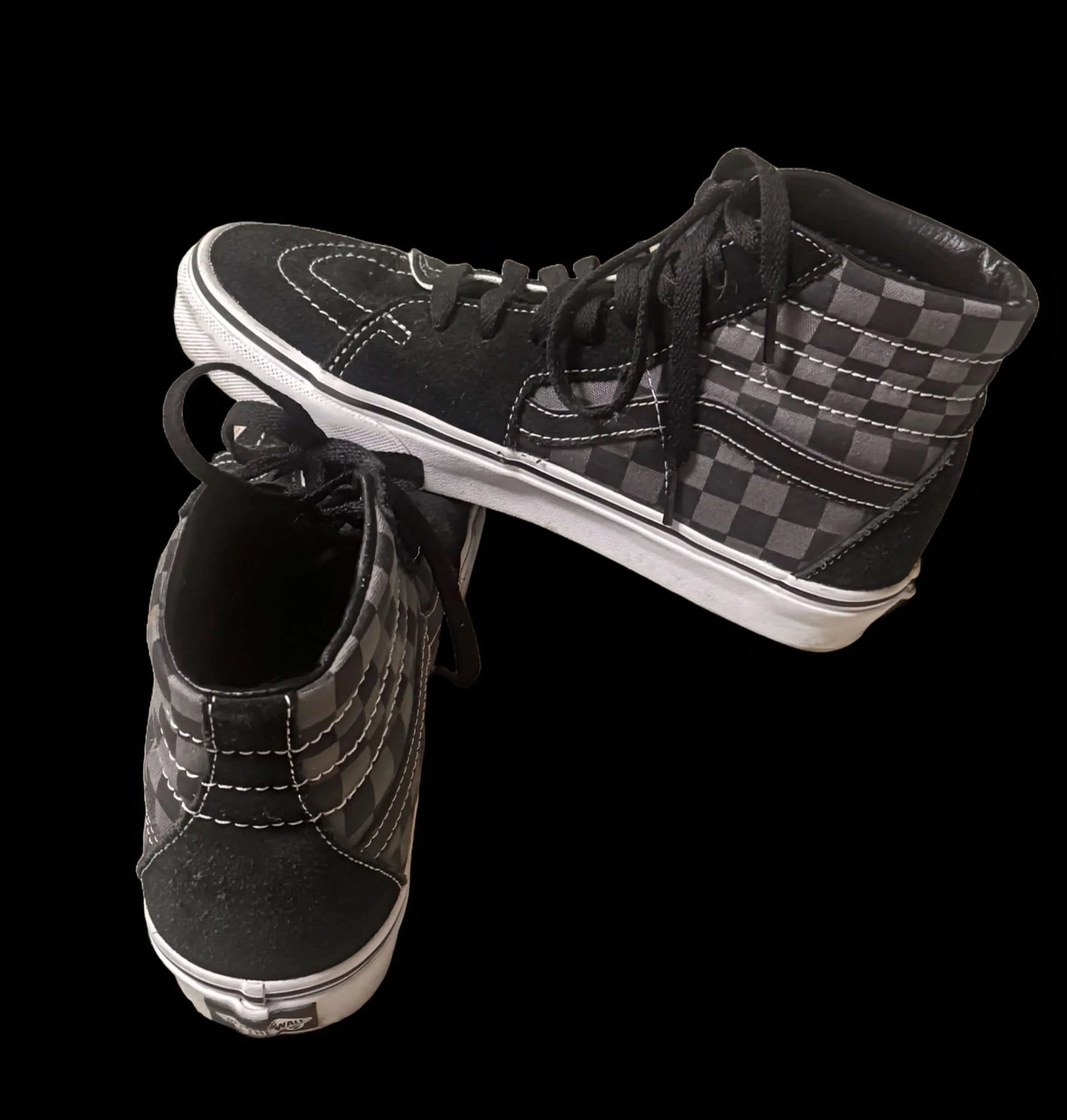 Vans high-top sneakers with black and gray checkerboard pattern on black background