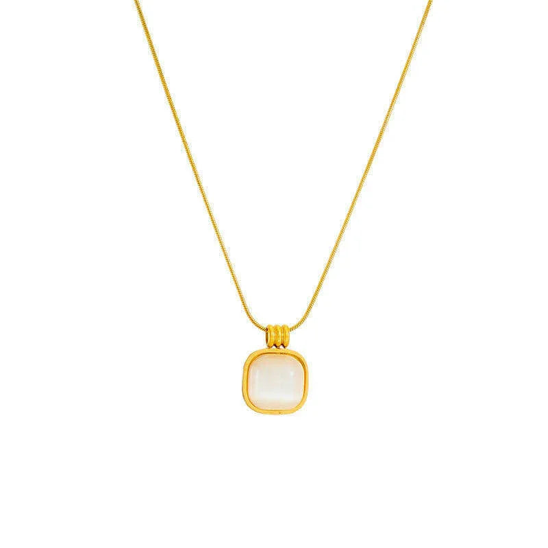Gold chain necklace with square white stone pendant on white background